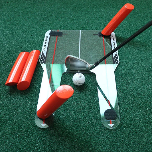 Golf training aid with club, ball, and red markers on a green surface